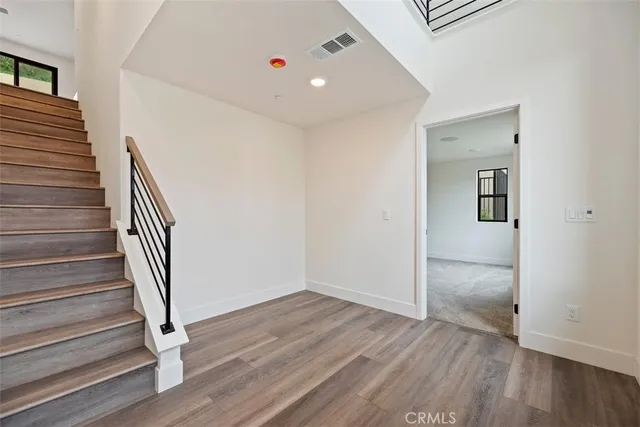 a view of a hallway with wooden floor and entryway