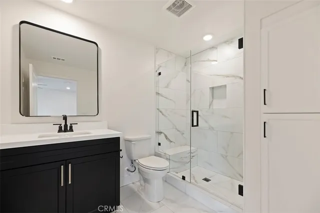 a bathroom with a shower sink mirror and toilet
