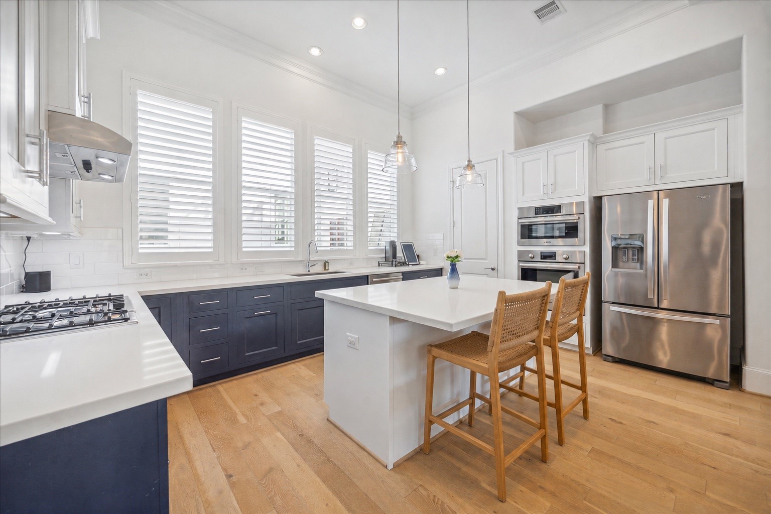 2714 Harvard Street Houston, TX 77008 - Photo 10 of 31 a kitchen with a sink a kitchen island wooden floors and stainless steel appliances