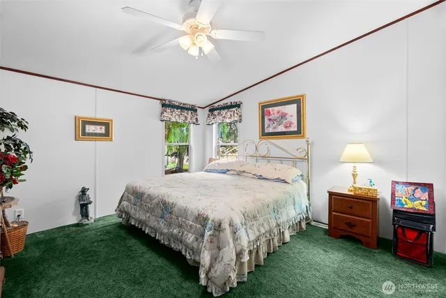 a spacious bedroom with a bed and a chandelier
