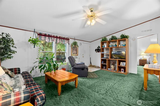 a living room with furniture a bookshelf and a large window