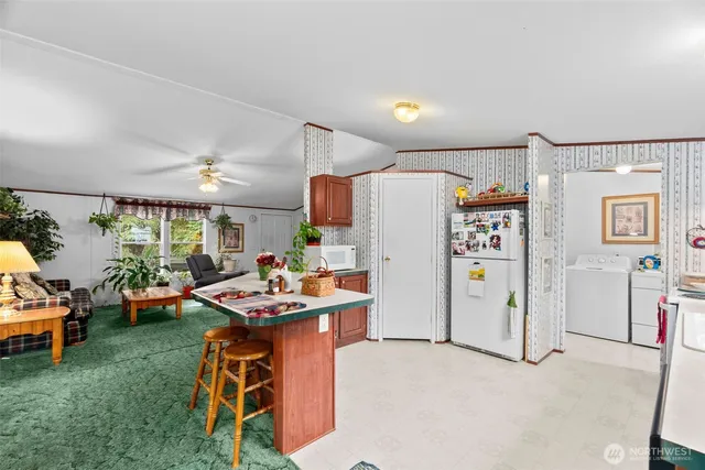 a kitchen with stainless steel appliances kitchen island granite countertop a refrigerator and a stove