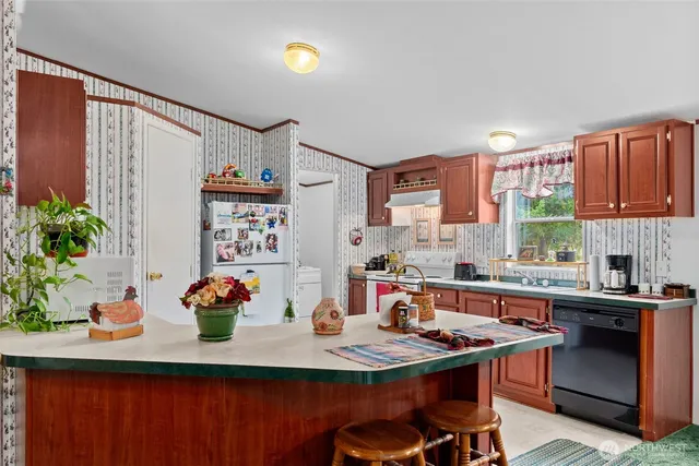 a kitchen with stainless steel appliances a sink a table and chairs in it
