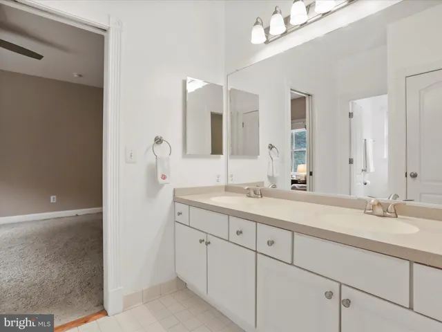 a bathroom with a granite countertop sink double and mirror