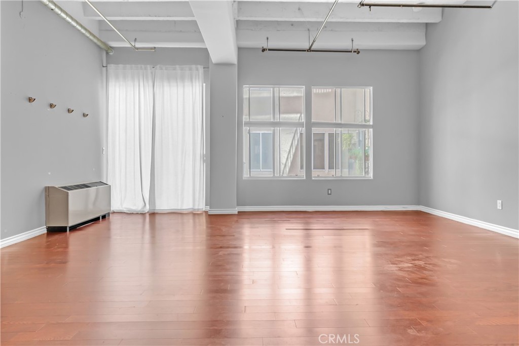 312 West 5th Street, Unit 1109 Los Angeles, CA 90013 - Photo 20 of 47 a view of an empty room with wooden floor and a window