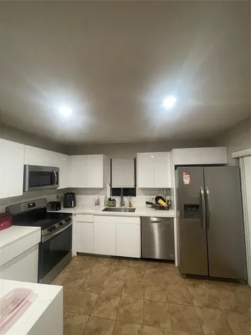 a kitchen with stainless steel appliances granite countertop a refrigerator sink and stove