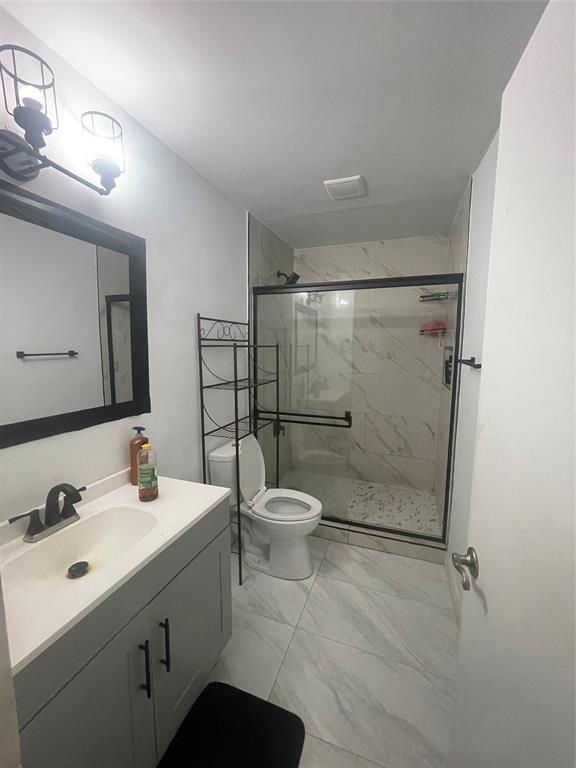 7823 Tam Oshanter Boulevard, Unit 7823 Pompano Beach, FL 33068 - Photo 3 of 6 a bathroom with a toilet sink vanity granite and shower