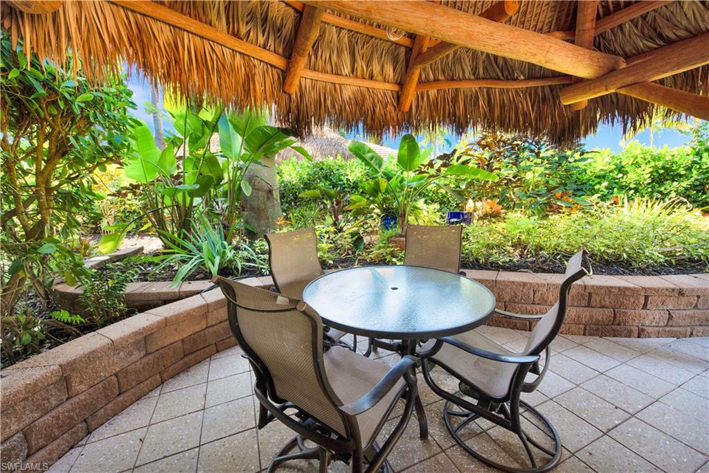 13553 Snapper Lane Naples, FL 34114 - Photo 12 of 24 a patio with table and chairs and potted plants