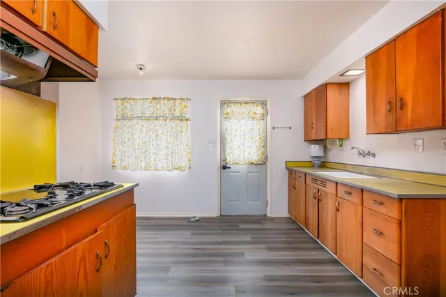 a kitchen with stainless steel appliances sink stove and wooden cabinets