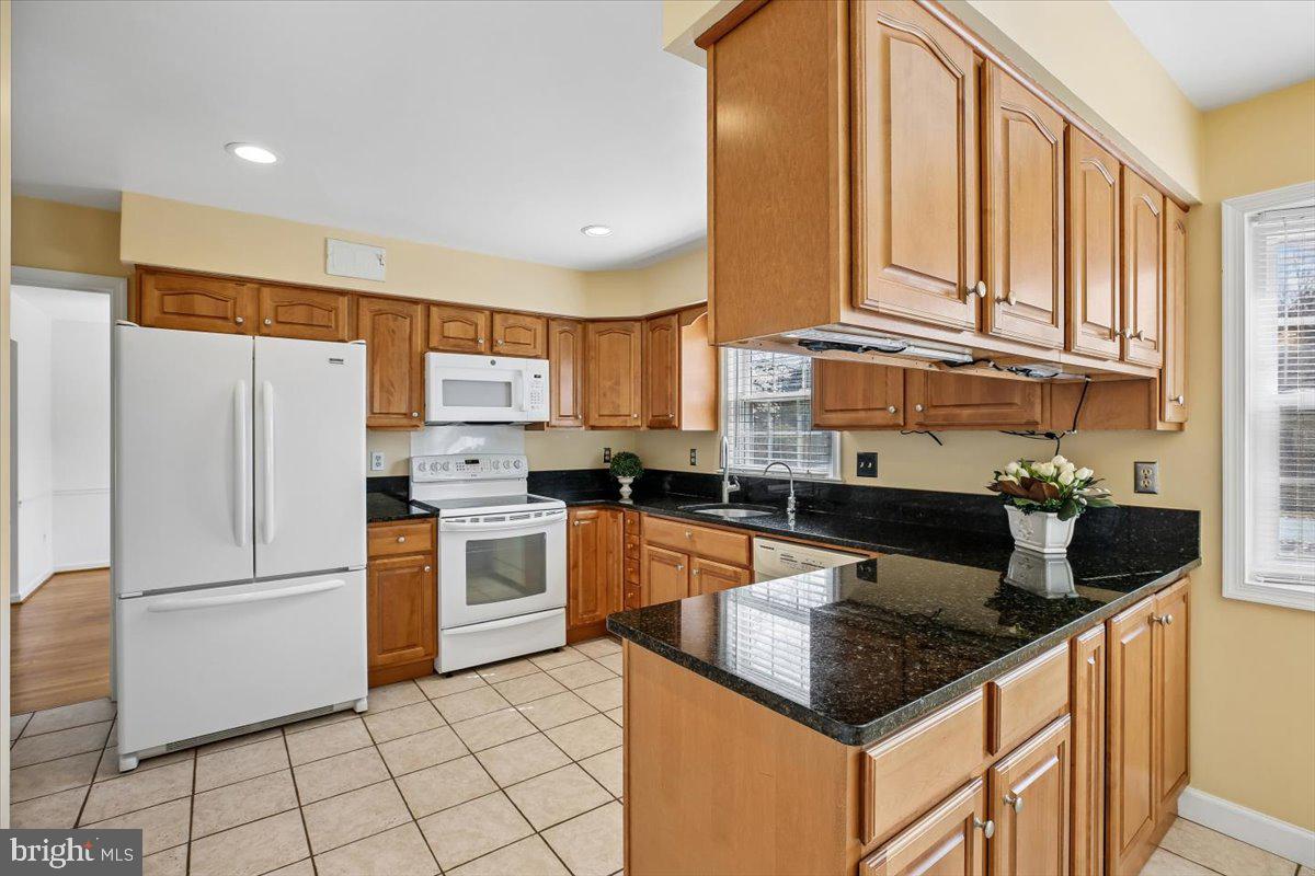 1913 Hopefield Road Silver Spring, MD 20905 - Photo 14 of 58 a kitchen with granite countertop a sink stainless steel appliances and white cabinets