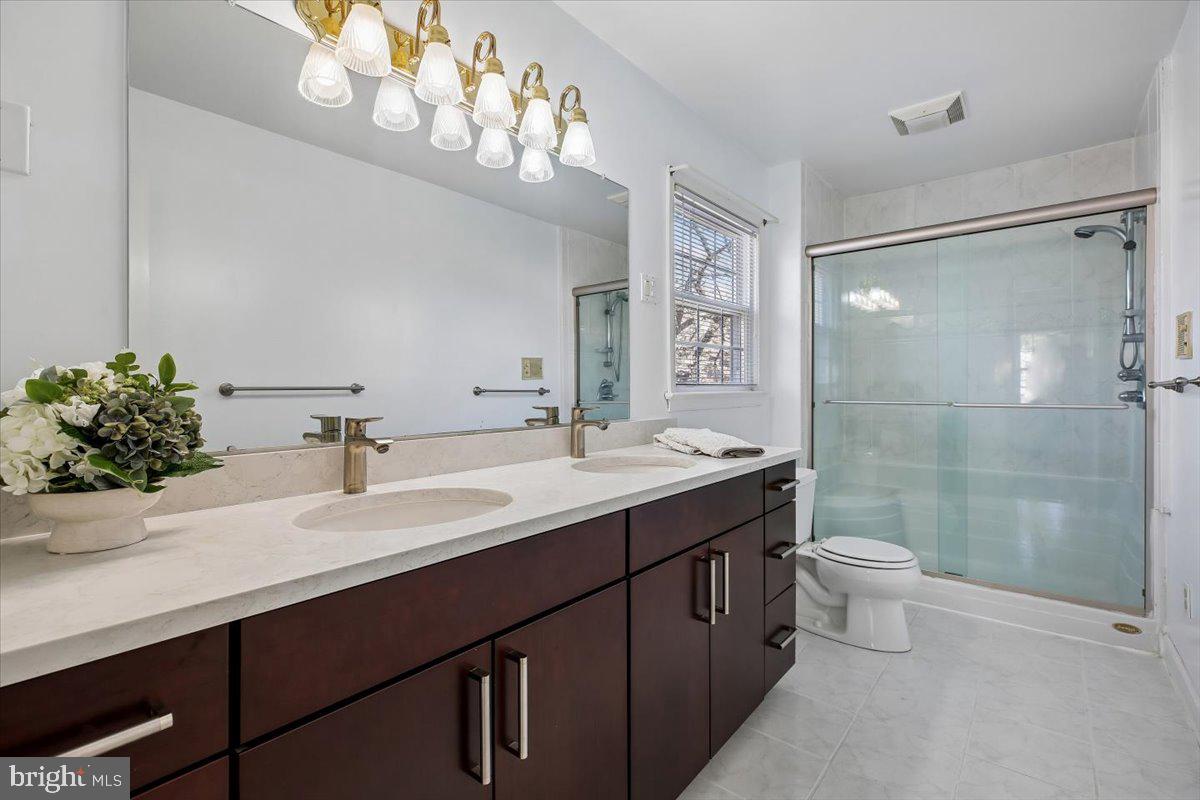 1913 Hopefield Road Silver Spring, MD 20905 - Photo 32 of 58 a bathroom with a double vanity sink mirror and toilet