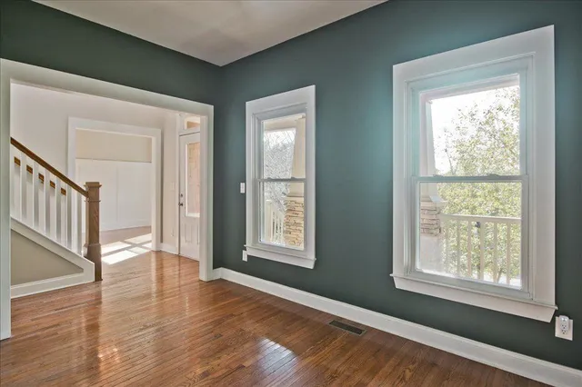 a view of empty room with wooden floor