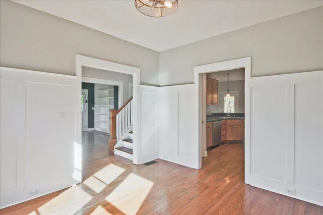 an empty room with wooden floor fireplace and window