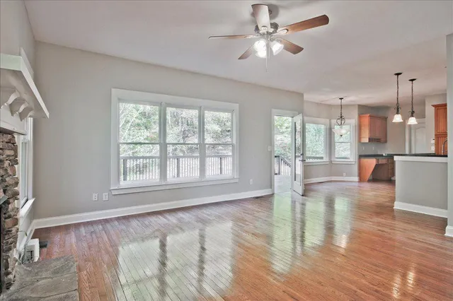 a kitchen with stainless steel appliances granite countertop wooden cabinets a sink a stove a dining table and chairs