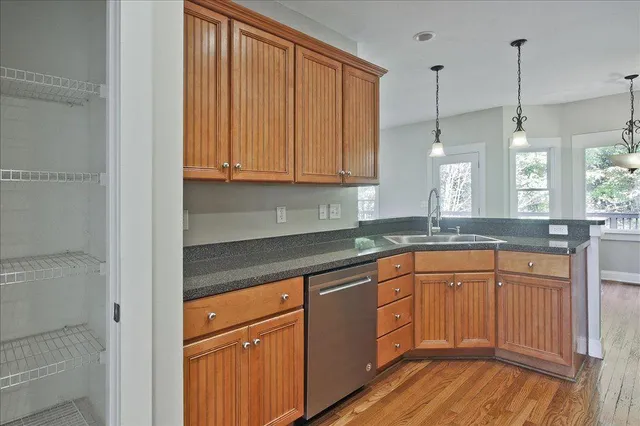 a kitchen with stainless steel appliances granite countertop a stove a sink and a window