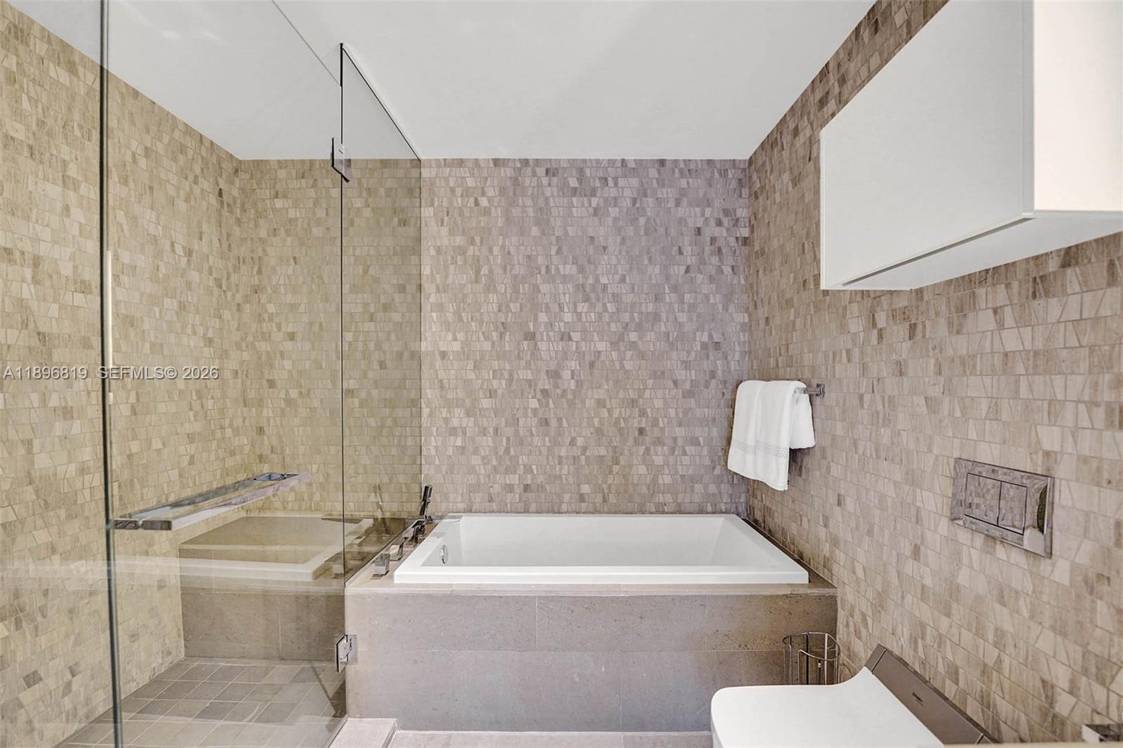 88 Southwest 7th Street, Unit 1408 Miami, FL 33130 - Photo 11 of 16 a bathroom with a sink a toilet and bathtub