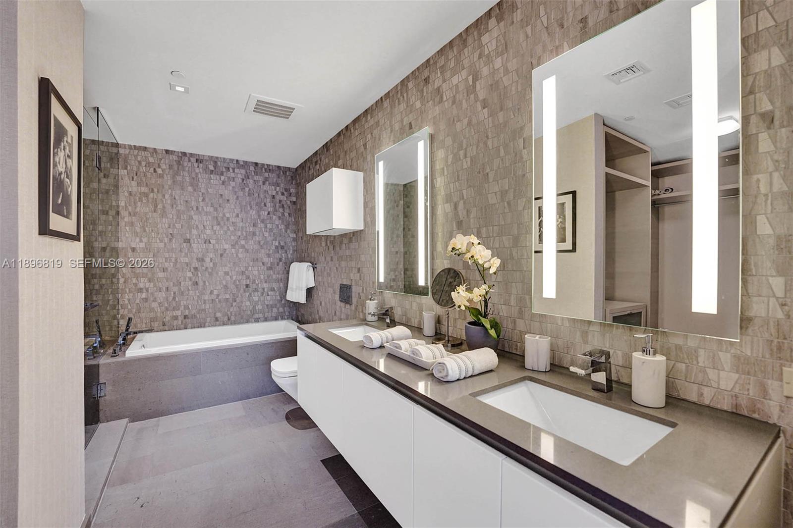 88 Southwest 7th Street, Unit 1408 Miami, FL 33130 - Photo 13 of 16 a bathroom with a double vanity sink a mirror and a bathtub