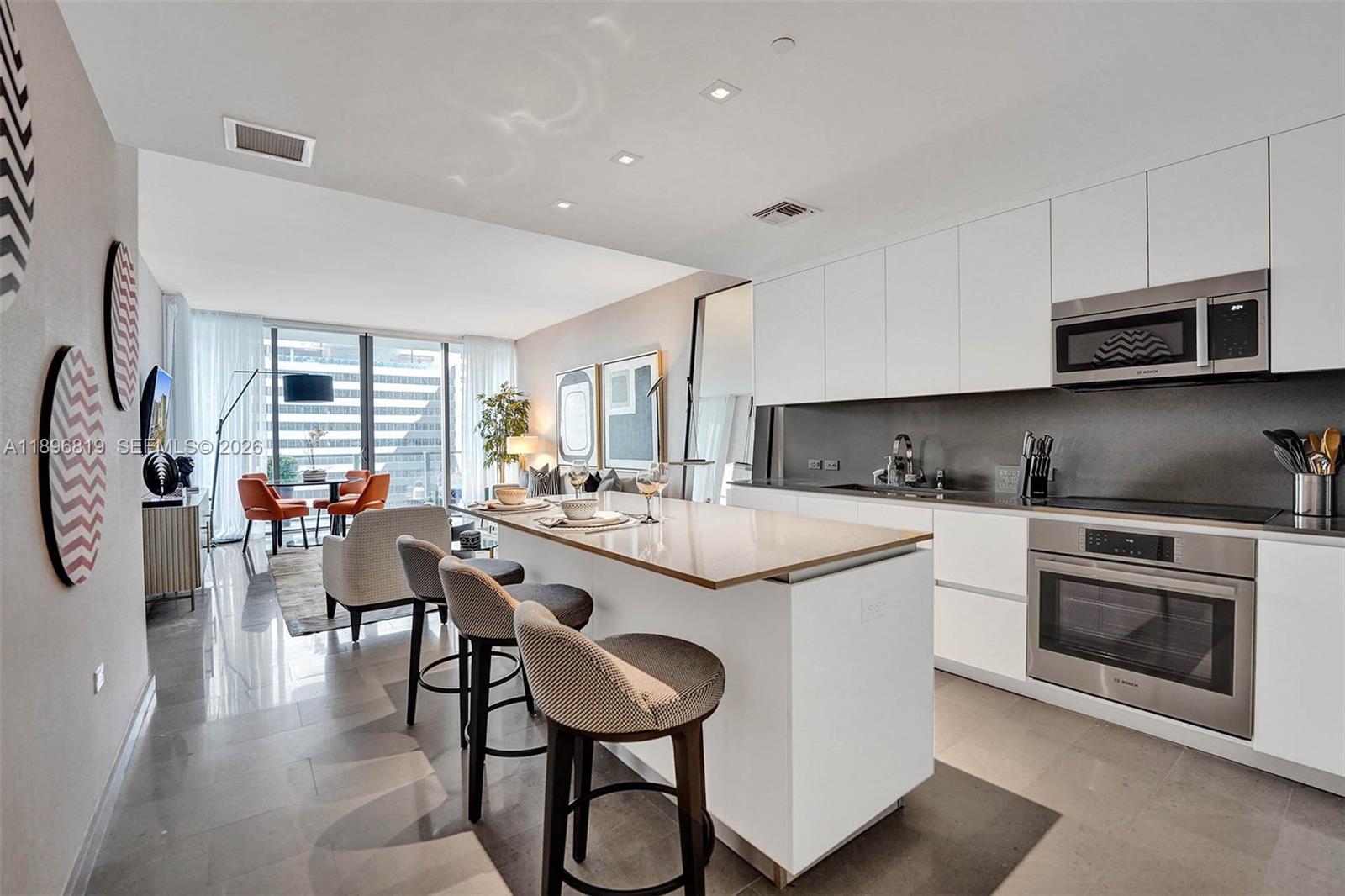 88 Southwest 7th Street, Unit 1408 Miami, FL 33130 - Photo 4 of 16 a kitchen with stainless steel appliances granite countertop a stove a sink and a refrigerator