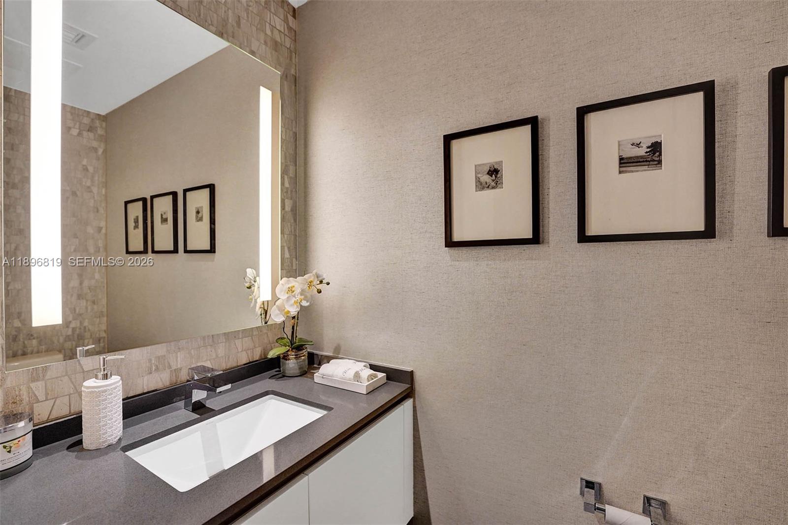 88 Southwest 7th Street, Unit 1408 Miami, FL 33130 - Photo 5 of 16 a bathroom with a sink and a mirror