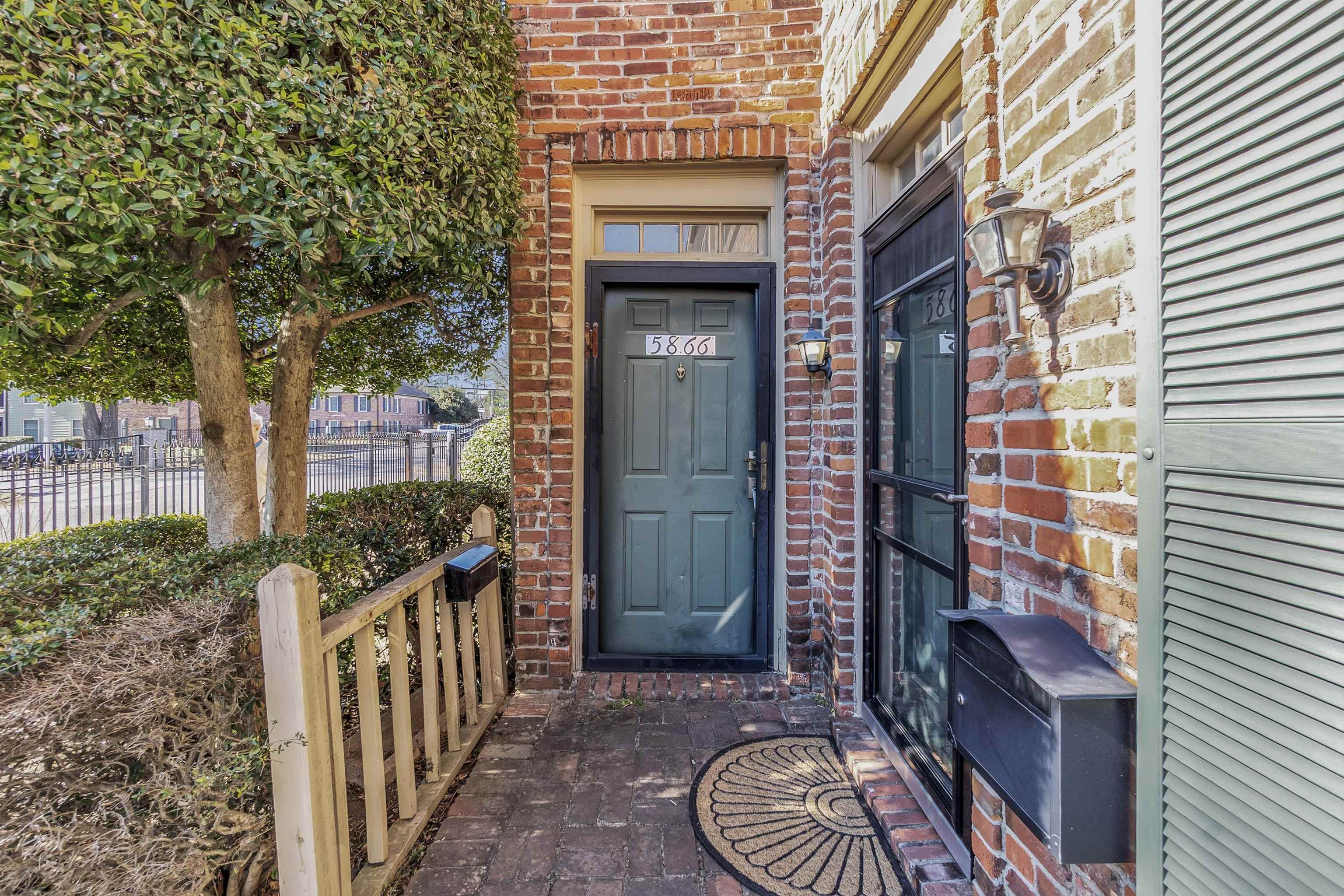 Doorway to property with brick siding and heating unit