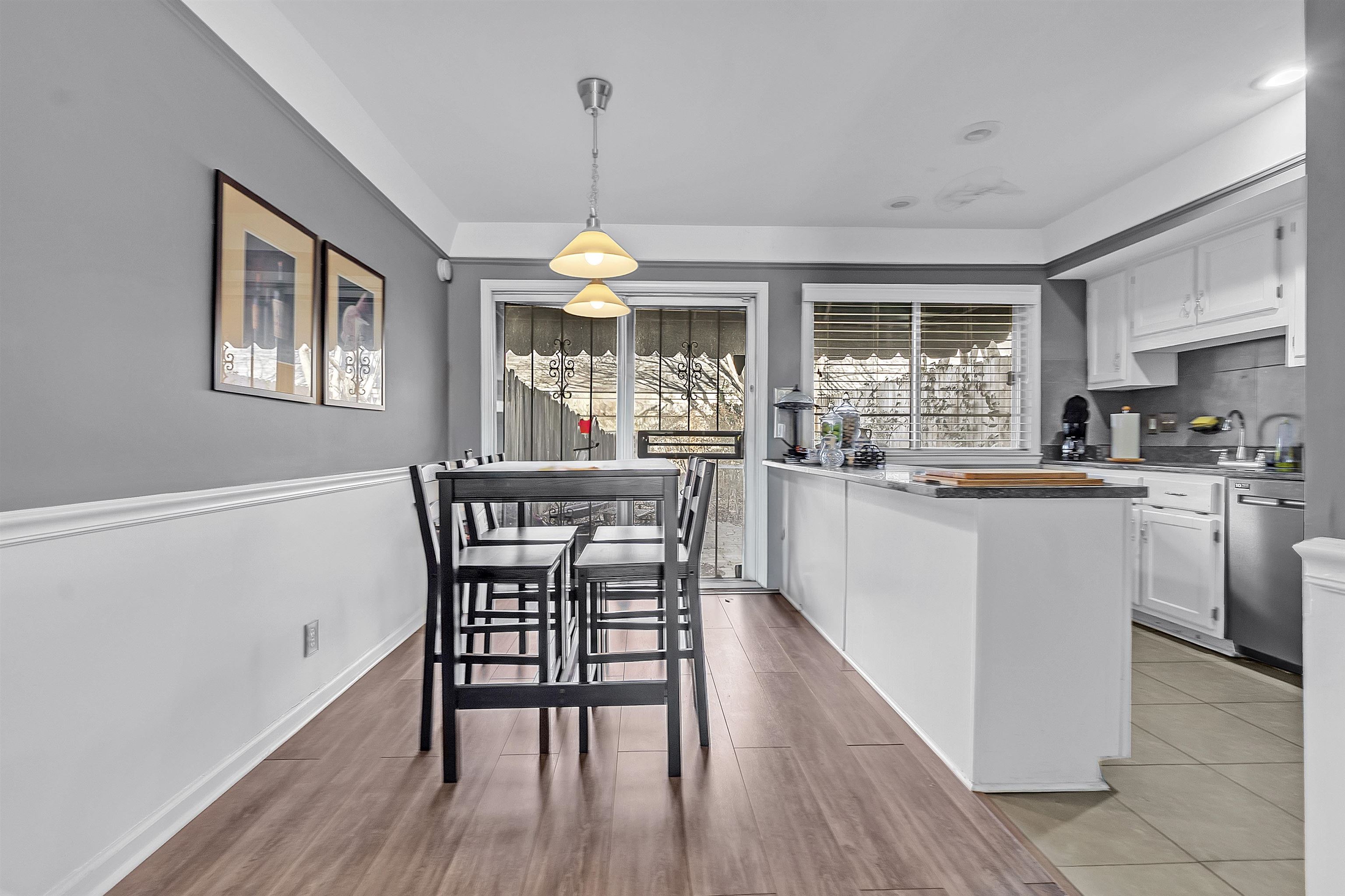 5866 Roxbury Drive, Unit 5866 Memphis, TN 38119 - Photo 5 of 16 Kitchen with white cabinetry, decorative light fixtures, light wood-style floors, and stainless steel dishwasher