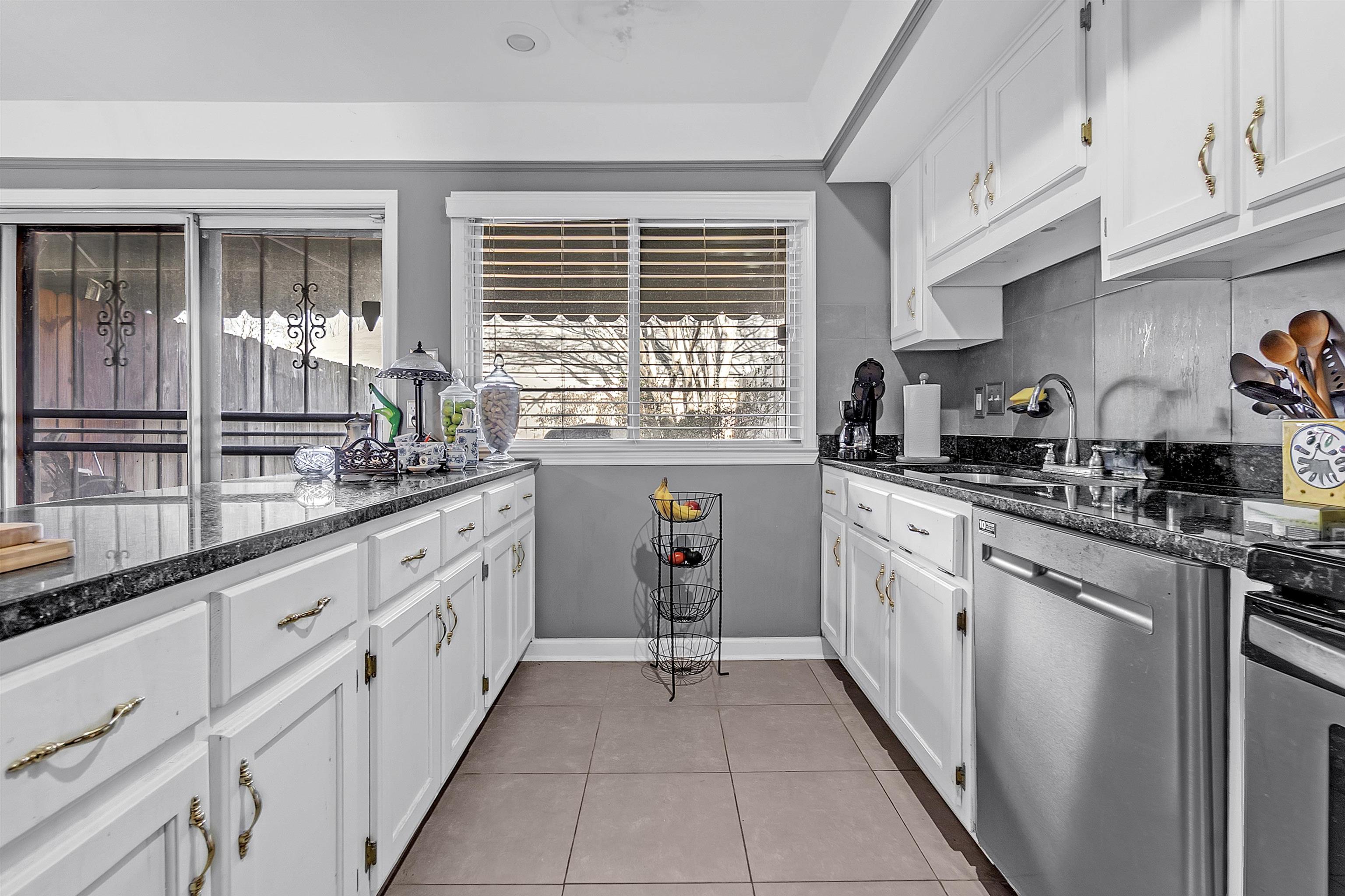 5866 Roxbury Drive, Unit 5866 Memphis, TN 38119 - Photo 6 of 16 Kitchen with dark stone counters, stainless steel dishwasher, white cabinets, and light tile patterned floors