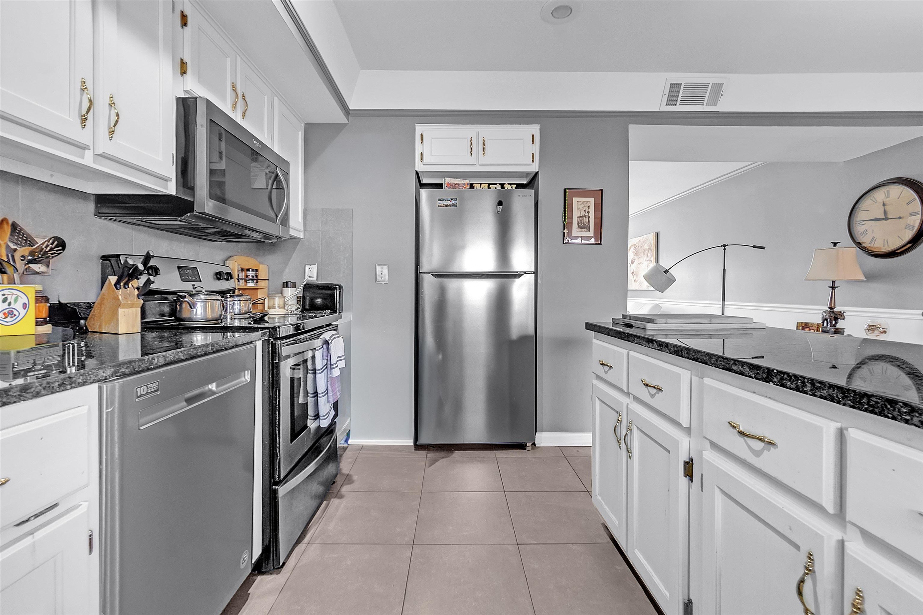 5866 Roxbury Drive, Unit 5866 Memphis, TN 38119 - Photo 7 of 16 Kitchen with stainless steel appliances, white cabinets, dark stone counters, and light tile patterned floors
