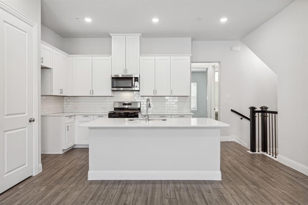 a kitchen with stainless steel appliances a white stove top oven a sink and a refrigerator