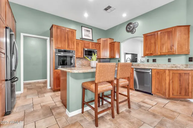 a kitchen with stainless steel appliances granite countertop a refrigerator and a sink