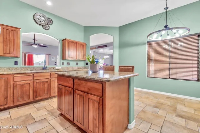 a kitchen with stainless steel appliances granite countertop a stove top oven a sink dishwasher and a refrigerator