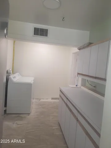 a kitchen with refrigerator and cabinets