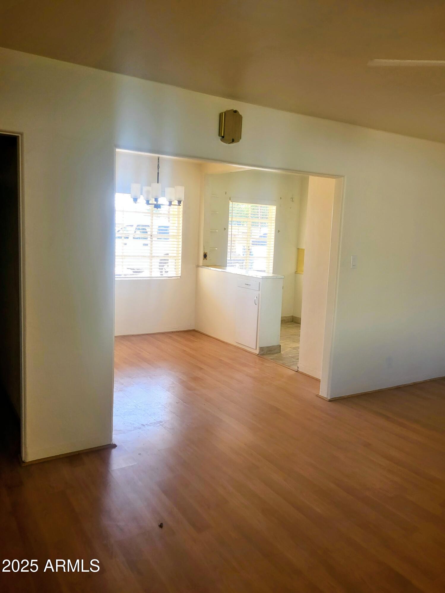 1704 West Colter Street, Unit 1 Phoenix, AZ 85015 - Photo 7 of 25 an empty room with wooden floor and windows