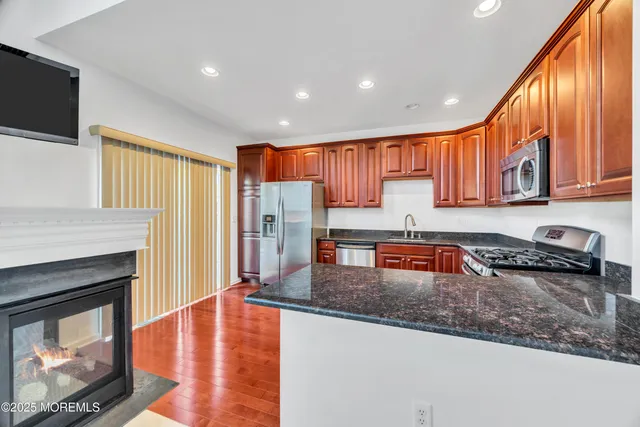 a kitchen with stainless steel appliances granite countertop a refrigerator a stove top oven a sink and dishwasher