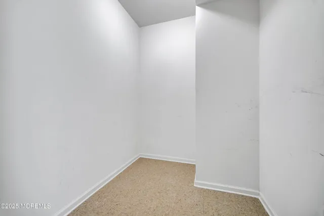 a view of a hallway to room with windows