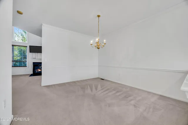 a view of a room with a chandelier fan and kitchen view