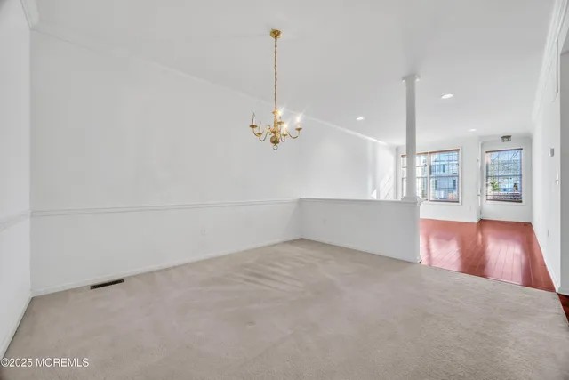 a view of a room with wooden floor and chandelier