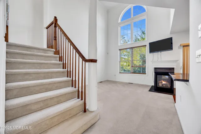 a view of an empty room with fireplace and a window