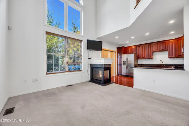 a living room with stainless steel appliances kitchen island furniture and a fireplace
