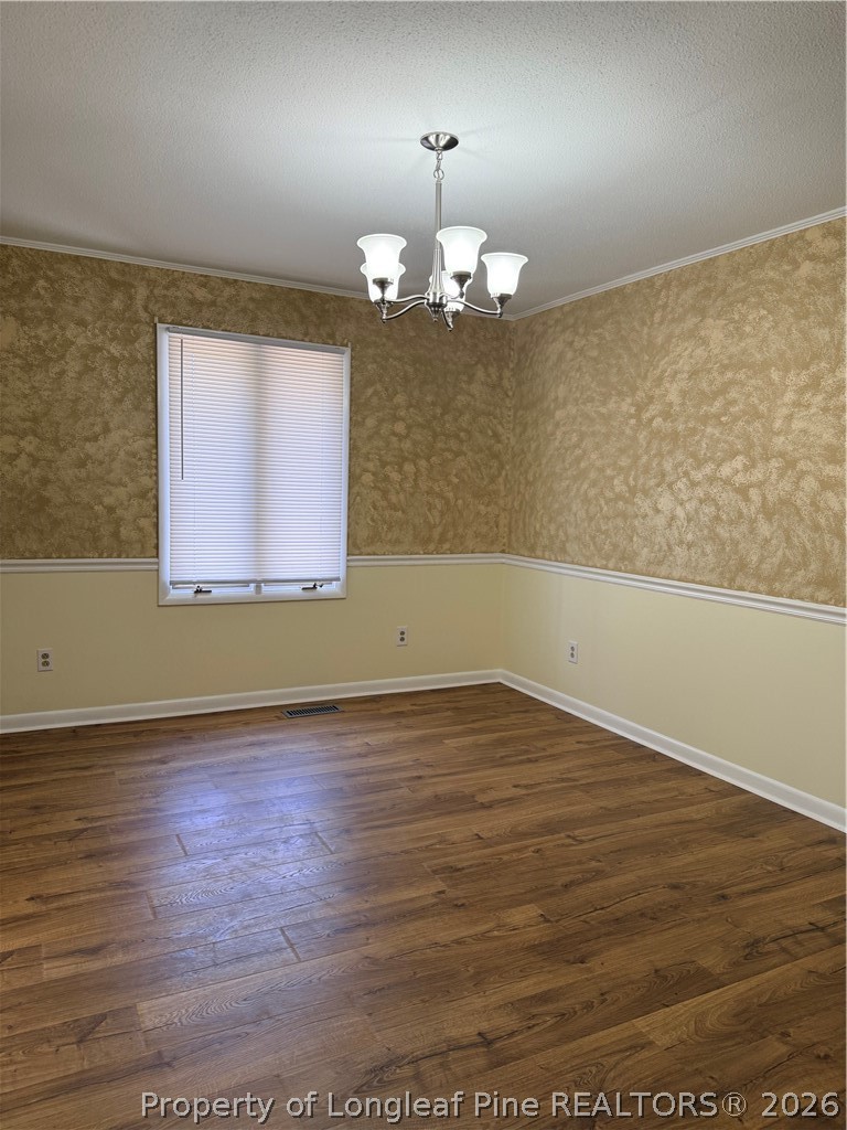 425 Dunmore Road Fayetteville, NC 28303 - Photo 6 of 21 an empty room with wooden floor chandelier fan and windows