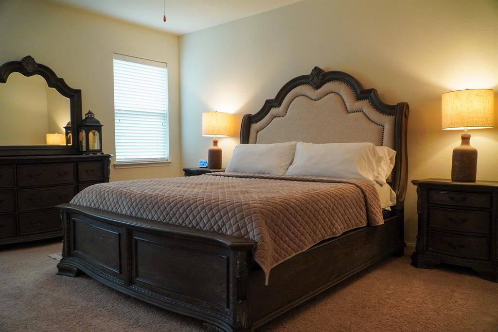 13624 Helix Bridge Way Crowley, TX 76036 - Photo 18 of 25 a bedroom with a bed and a dresser with mirror
