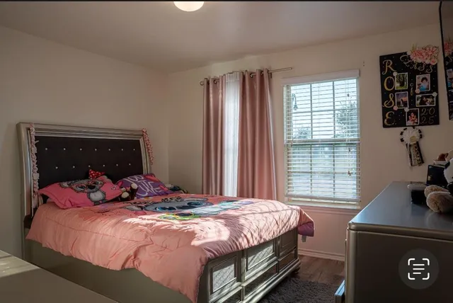 a bedroom with a bed and wooden floor