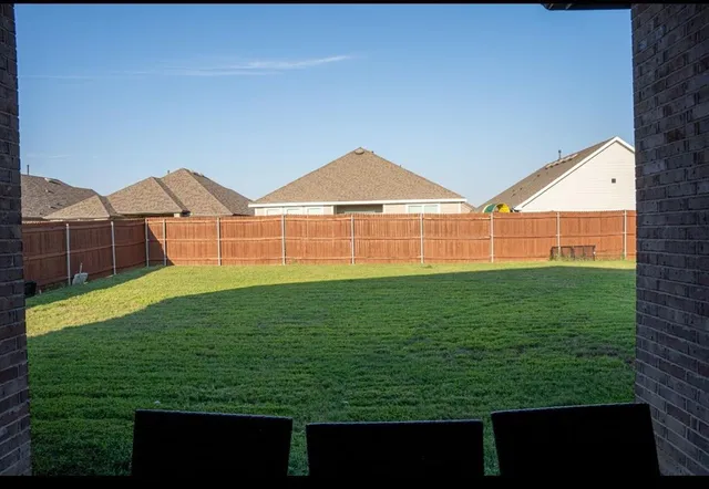 a view of a big house with a big yard and large trees