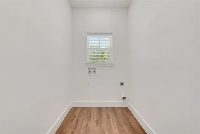 a view of a small space with wooden floor and a window