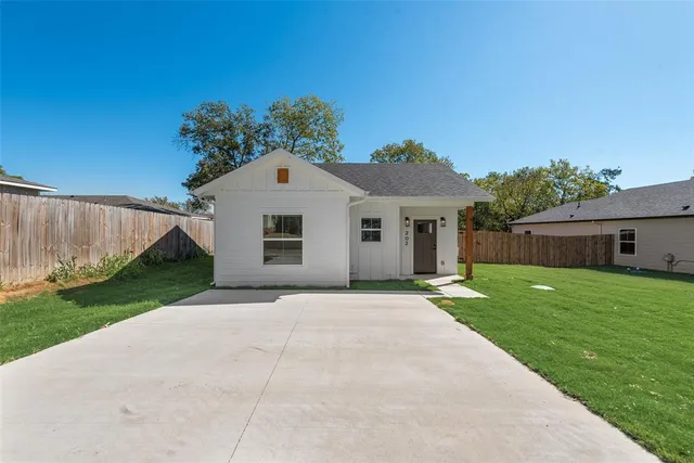 a front view of house with a yard and trees