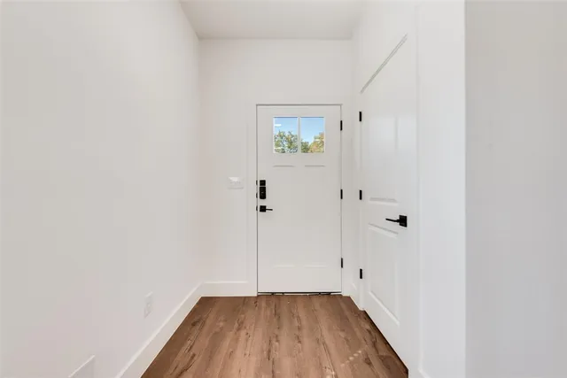 a view of an empty room with wooden floor