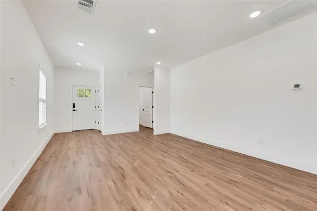 a view of empty room with wooden floor