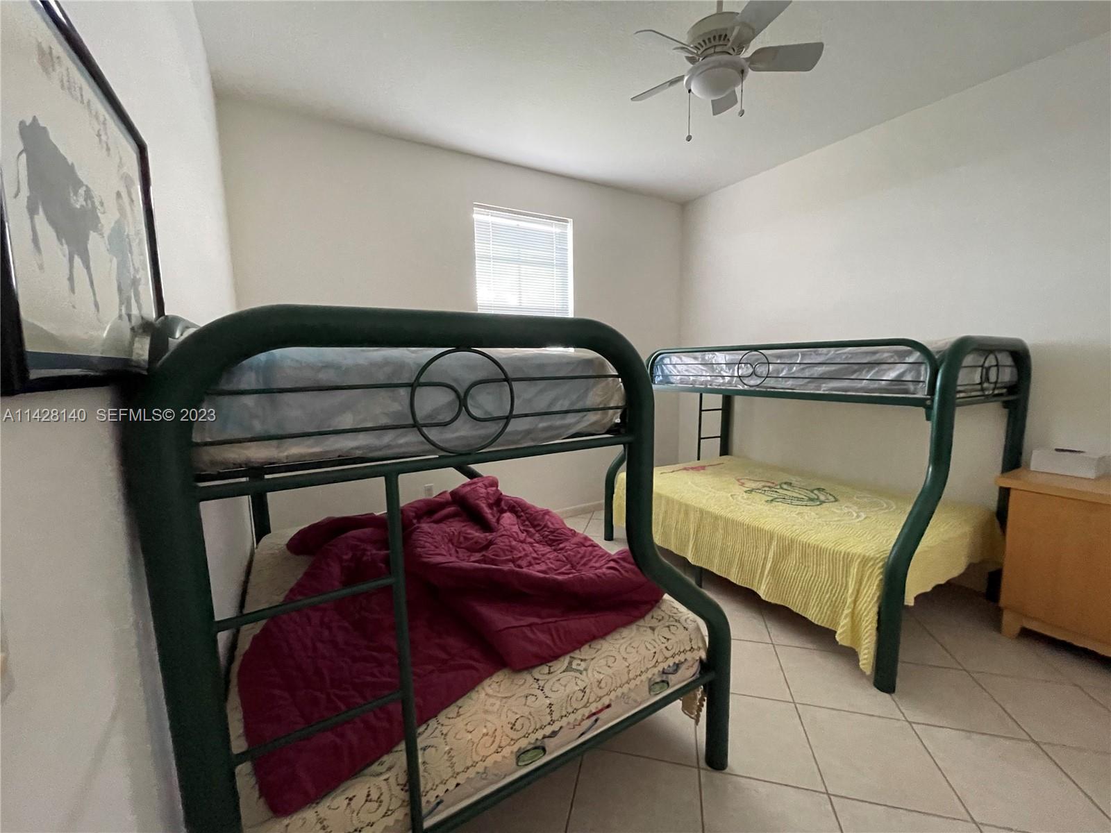 33300 Southwest 202nd Avenue Homestead, FL 33030 - Photo 16 of 42 a bedroom with two beds and window