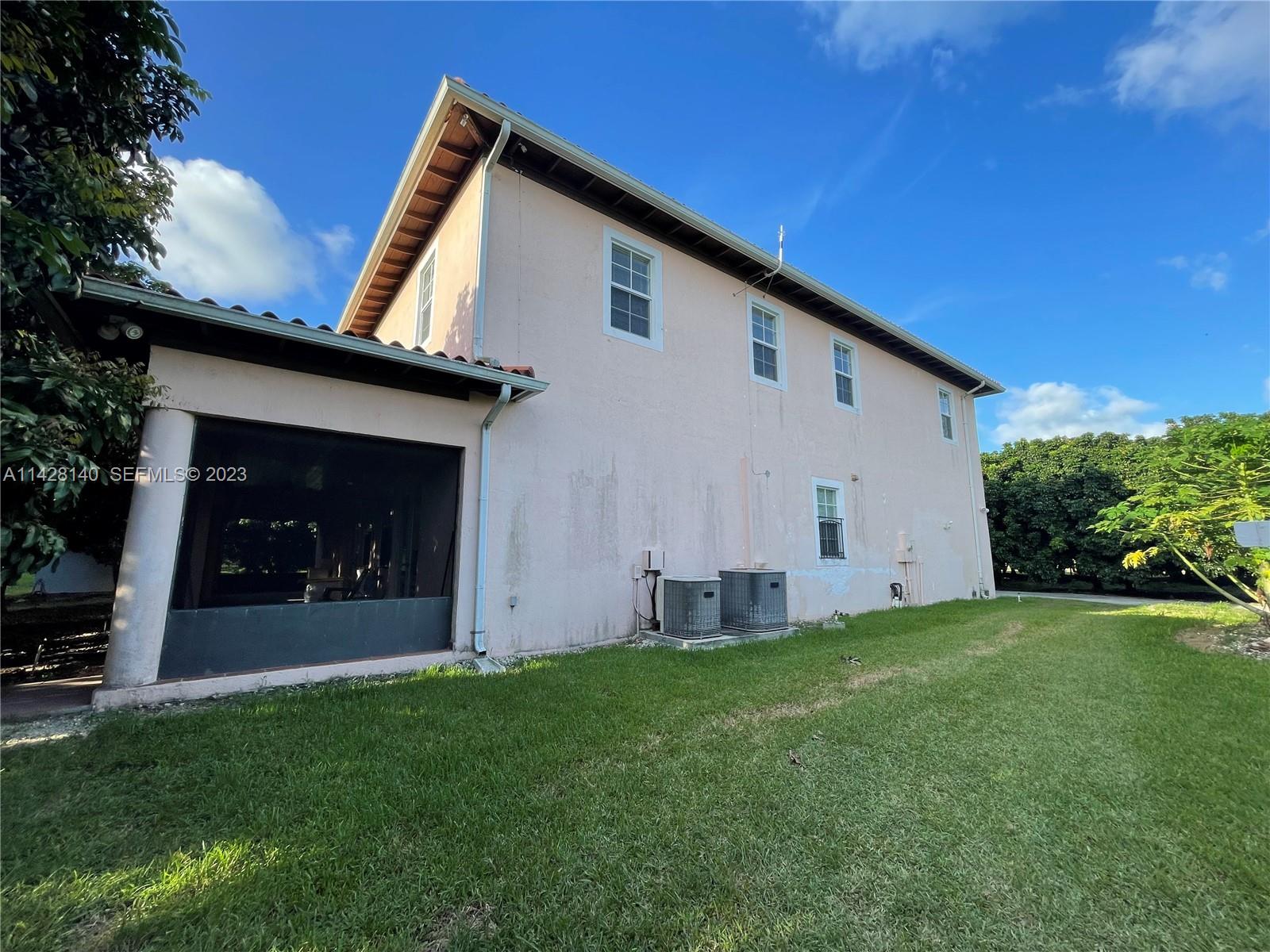 33300 Southwest 202nd Avenue Homestead, FL 33030 - Photo 24 of 42 a front view of a house with a yard and garage