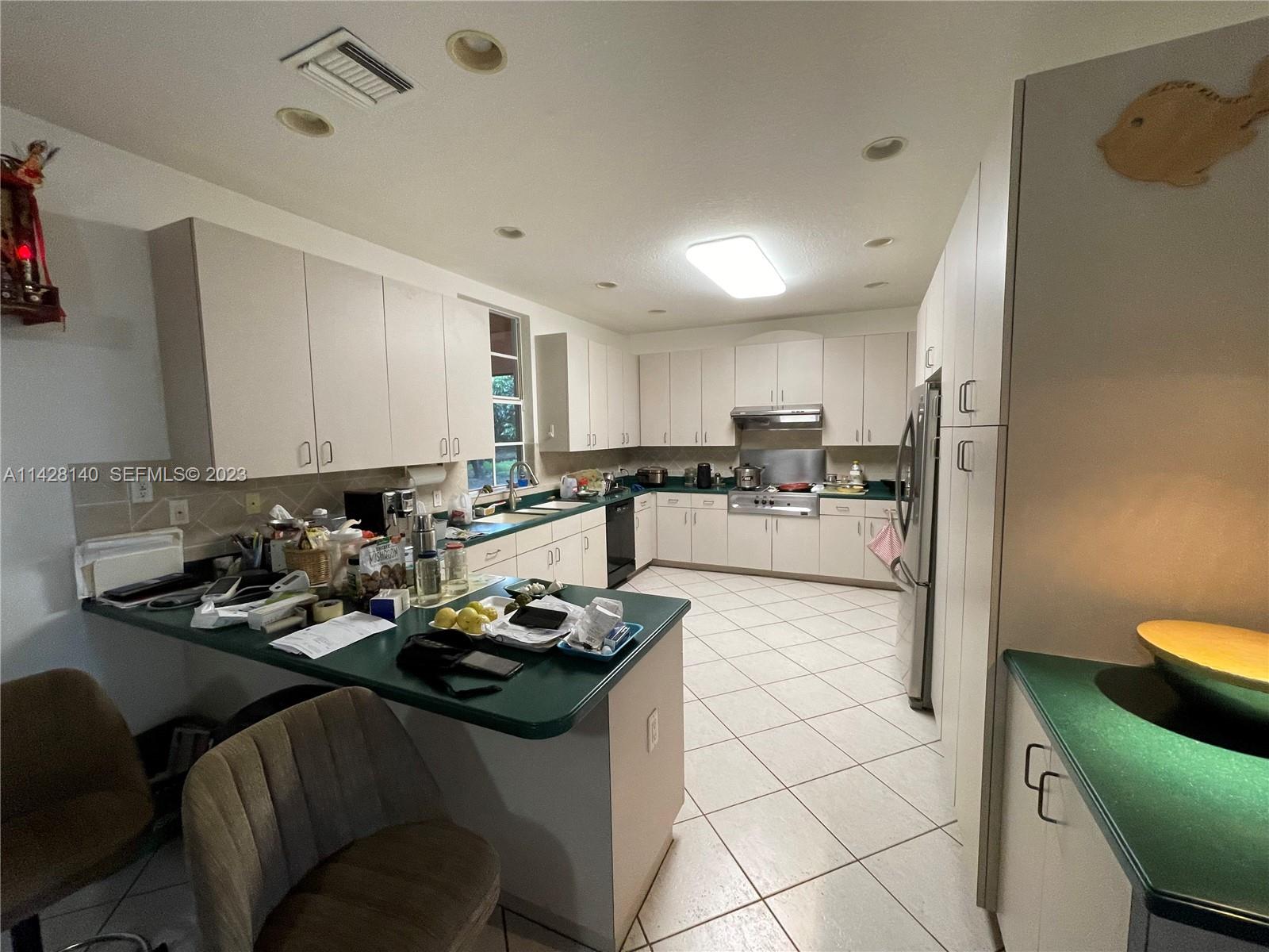 33300 Southwest 202nd Avenue Homestead, FL 33030 - Photo 4 of 42 a kitchen with sink refrigerator and cabinets