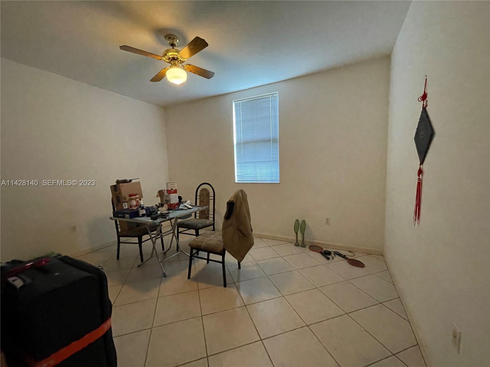 33300 Southwest 202nd Avenue Homestead, FL 33030 - Photo 9 of 42 a work room with furniture and a ceiling fan
